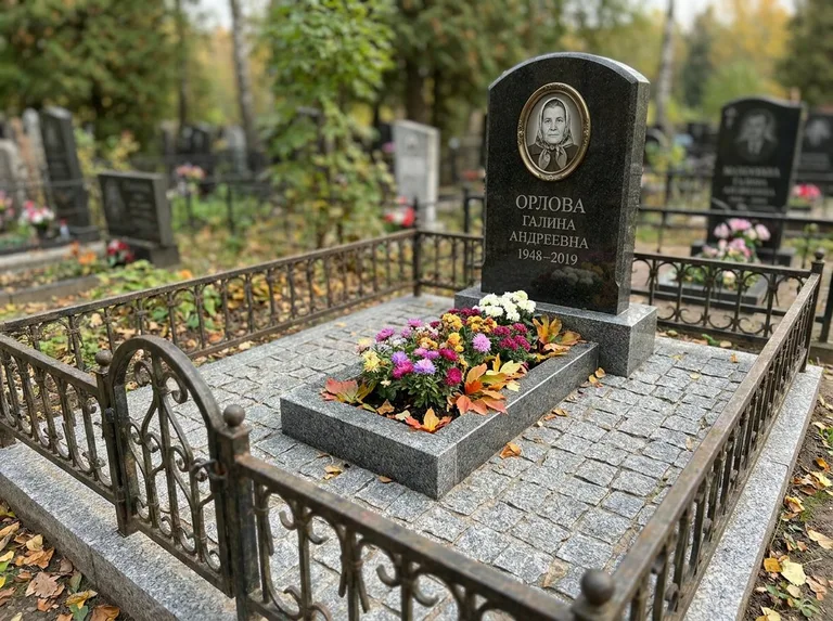 Благоустроенное захоронение с гранитной плиткой, оградой и цветником в Саратове