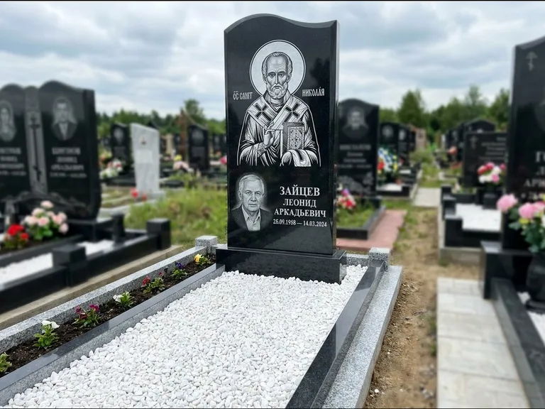 Памятник с гравировкой иконы: стела с крестообразным навершием — икона в резной рамке-киоте, газон без ограды, стриженая трава, работа «Раевская» в Саратове
