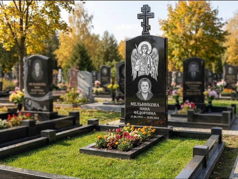 Памятник с гравировкой иконы: округлая стела-медальон с ликом — гравировка Богородицы «Семистрельная», луговые травы и полевые цветы за участком, работа «Гущин» в Саратове