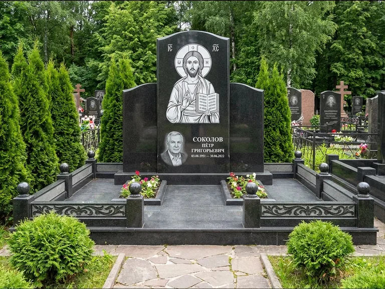 Памятник с гравировкой иконы: широкая горизонтальная лежачая плита-стела — икона в резной рамке-киоте, серая гравийная отсыпка с бордюром, работа «Богданова» в Саратове