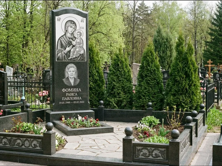 Памятник с гравировкой иконы: высокий гранёный обелиск с крестом-навершием — гравировка образа Матроны Московской, открытый участок без ограды, работа «Третьяков» в Саратове