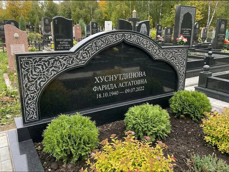 Мусульманский памятник: вытянутая горизонтальная семейная стела с аркой — белая гравировка силуэта мечети с минаретами, участок с декоративными кустами, работа «Зарипова» в Саратове
