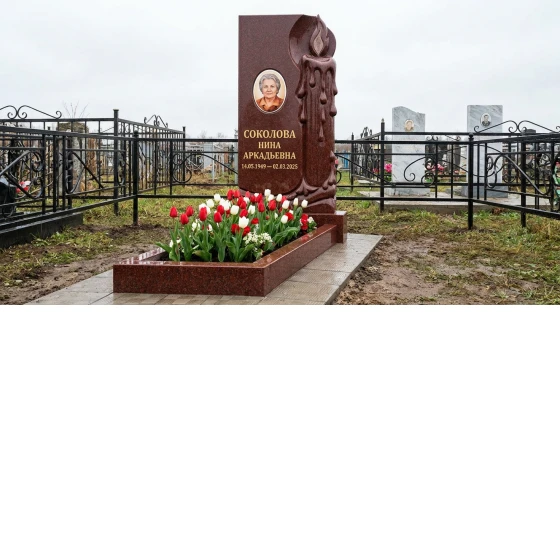 Мемориал с зажженной свечой из красного гранита